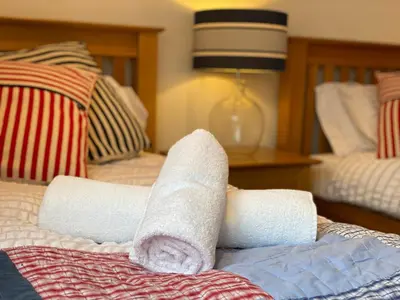 a roll of toilet paper on a bed at OHANA HOUSE - Unbeatable Location - UK's Best Beaches in Newquay