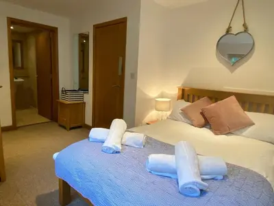 a bedroom with a bed with towels on it at OHANA HOUSE - Unbeatable Location - UK's Best Beaches in Newquay