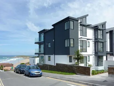 a black and white building with cars parked in front of it at Rosen in Crantock