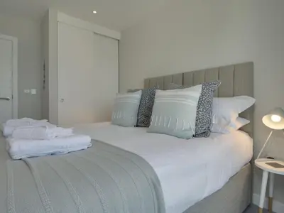 a large bed with white sheets and pillows at Rosen in Crantock