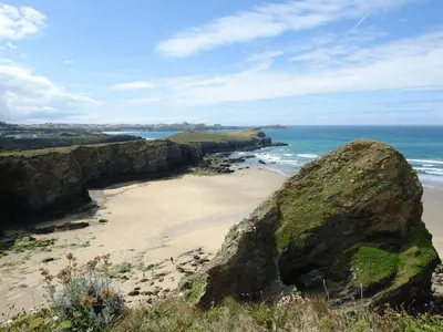 a beach with a large rock and the ocean at Rosen in Crantock