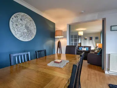 a dining room with a table and a living room at Blue Seas in Saint Mawes