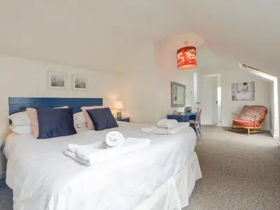 a bedroom with a large white bed with towels on it at Blue Seas in Saint Mawes