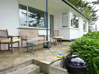 a patio with a grill and benches on a house at Blue Seas in Saint Mawes