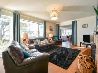 a living room with a leather couch and a television at Blue Seas in Saint Mawes