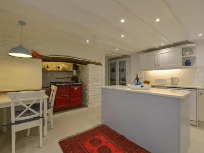 a kitchen with a white counter and a red stove at Little Barn Cottage in Portloe