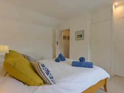 a bedroom with a bed with blue stuffed animals on it at Little Barn Cottage in Portloe
