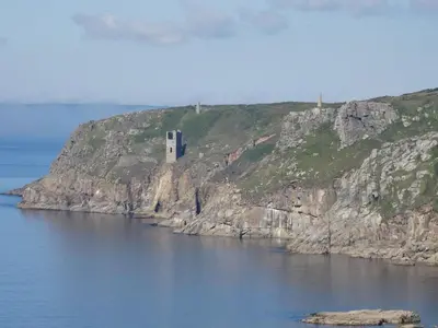 a building on the side of a cliff in the water at The Hayloft in Breage