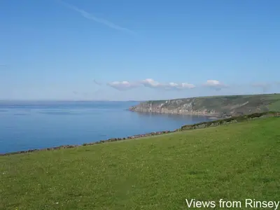a view of the ocean from a grassy hill at The Hayloft in Breage
