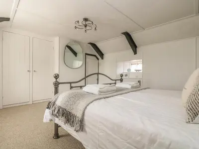 a bedroom with a large bed with white sheets at Boundys House in St Ives
