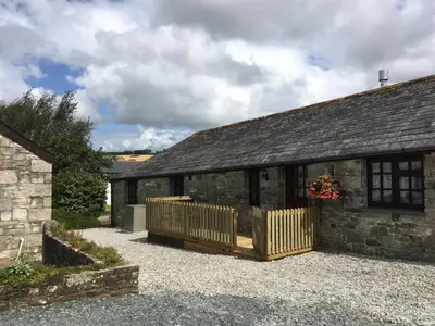 an external view of a stone building with a porch at Maple & Beech Barns in Truro