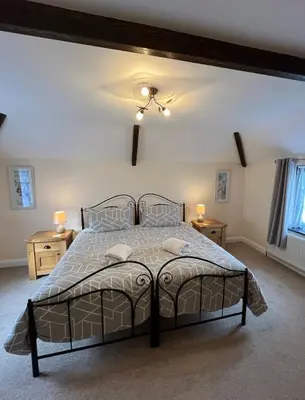 a bedroom with a large bed with two night stands at Maple & Beech Barns in Truro