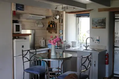 a kitchen with a table with chairs and a sink at Sky Cottage in Golant village near Fowey in Fowey