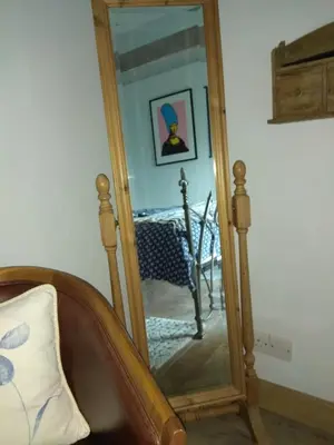 a mirror with a wooden frame in a room at Sky Cottage in Golant village near Fowey in Fowey
