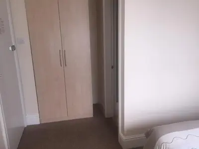 a bedroom with a closet and a white cabinet at Seashells in Newquay