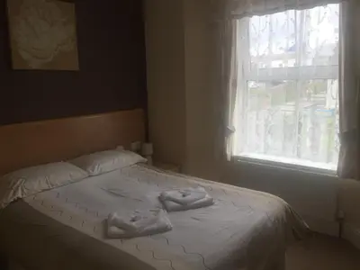 a bed with two towels on it with a window at Seashells in Newquay