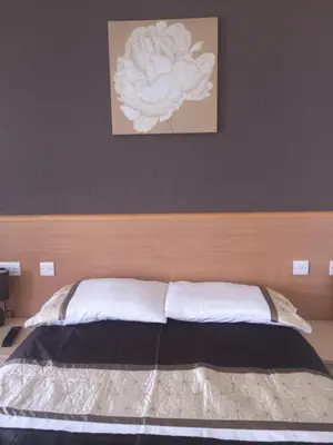 a bed with a wooden headboard in a bedroom at Seashells in Newquay