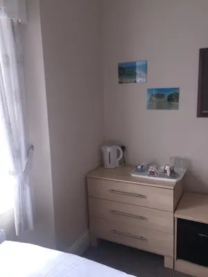 a kitchen with a sink and a dresser at Seashells in Newquay