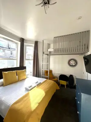 a bedroom with a large bed with a yellow blanket at Town Lodge in Newquay