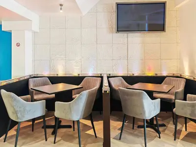 a restaurant with two tables and chairs and a television on the wall at Town Lodge in Newquay