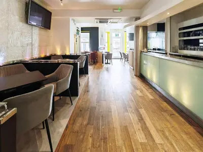 a restaurant with a bar with chairs and tables at Town Lodge in Newquay