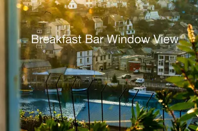 a sign for a breakfast bar window with a view of a city at Looe Self Catering in Looe