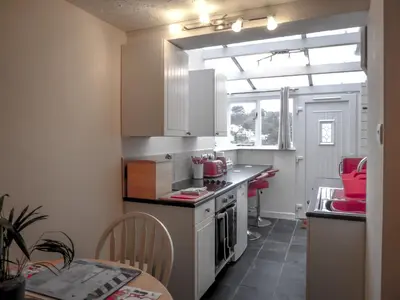 a kitchen with a counter and a table in it at Looe Self Catering in Looe