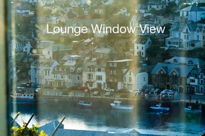 a window view of a town with boats in the water at Looe Self Catering in Looe