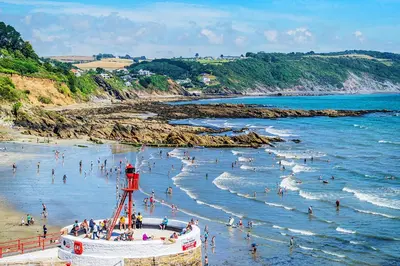 a group of people in the water at a beach at Looe Self Catering in Looe