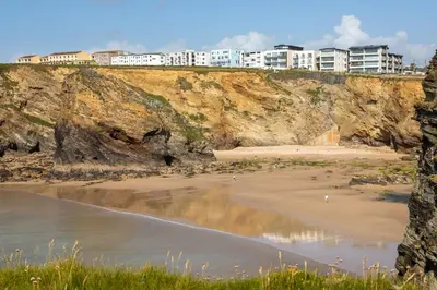 a beach with buildings on top of a cliff at Kenton in Newquay