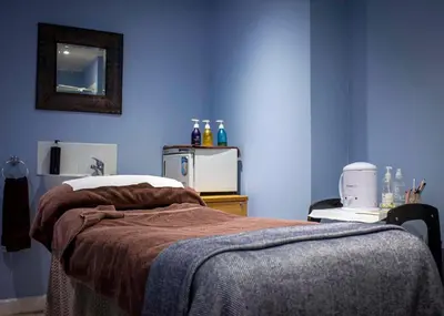 a bedroom with a bed with a blue wall at The Hannafore Point Hotel in Looe