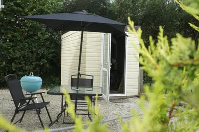 a table and chairs and an umbrella in front of a shed at The annex, Ruthvose in Saint Columb Major