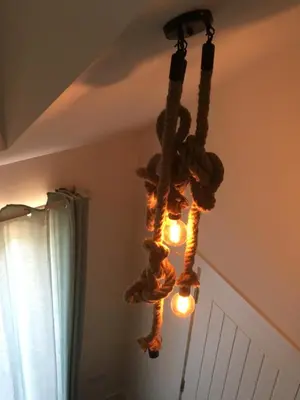 a chandelier made out of logs and lights at Little Fernleigh in Perranporth