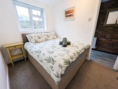 a small bedroom with a bed with a night stand at South Fistral View Apartment in Newquay