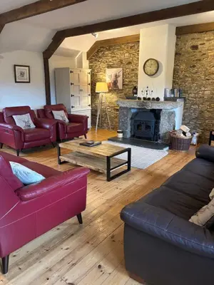 a living room with couches and a fireplace at Tregolls Farm Cottages in Wadebridge