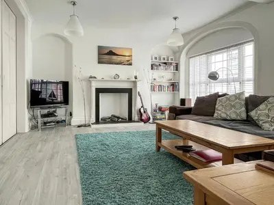 a living room with a couch and a fireplace at Seaglass in Marazion