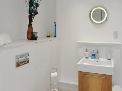 a white bathroom with a sink and a mirror at Seaglass in Marazion