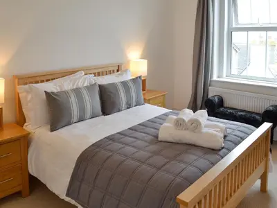 a bedroom with a large bed with towels on it at Seaglass in Marazion