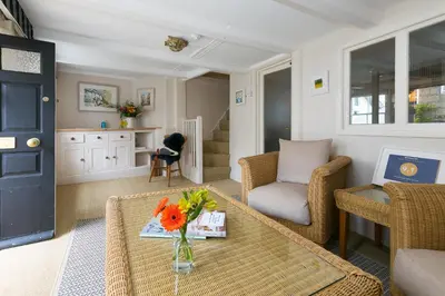 a living room with a table with flowers on it at Anchorage Guest House, St Ives in St Ives