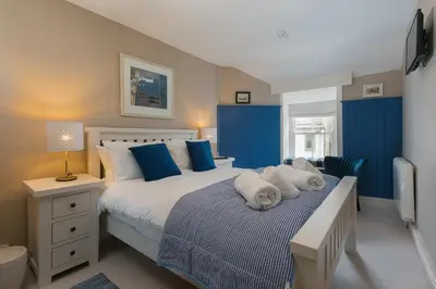 a bedroom with a bed with two dogs laying on it at Anchorage Guest House, St Ives in St Ives