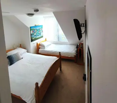 a bedroom with two beds and a television in it at St Breca in Newquay