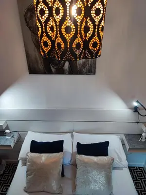 a bedroom with a bed with two pillows and a painting at St Breca in Newquay