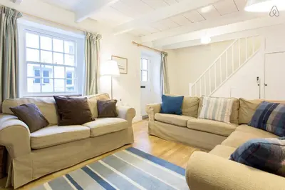 a living room with two couches and a staircase at Fisherman's Cottage in Saint Mawes