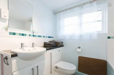 a bathroom with a sink and a toilet and a window at Fisherman's Cottage in Saint Mawes
