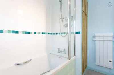 a white bathroom with a shower and a sink at Fisherman's Cottage in Saint Mawes