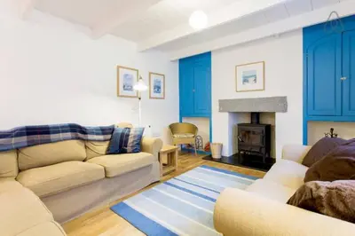 a living room with a couch and a fireplace at Fisherman's Cottage in Saint Mawes