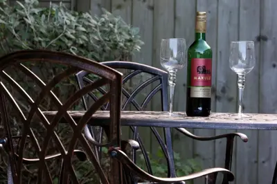 a bottle of wine sitting on a table with two glasses at Tehidy Holiday Park in Illogan