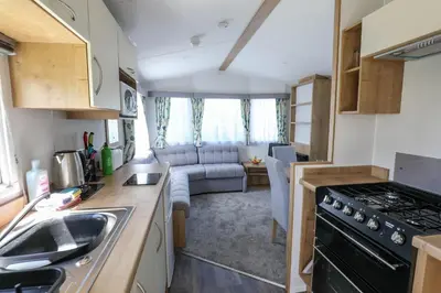 a kitchen and living room of a caravan at Tehidy Holiday Park in Illogan