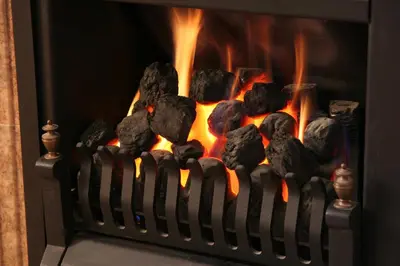 a fire in a fireplace with rocks in it at Mandeley Guest House in Helston