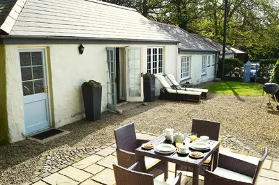 a table and chairs in the backyard of a house at Spring Water Barn in Helston